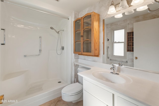 bathroom featuring vanity, toilet, a shower, and tile patterned flooring