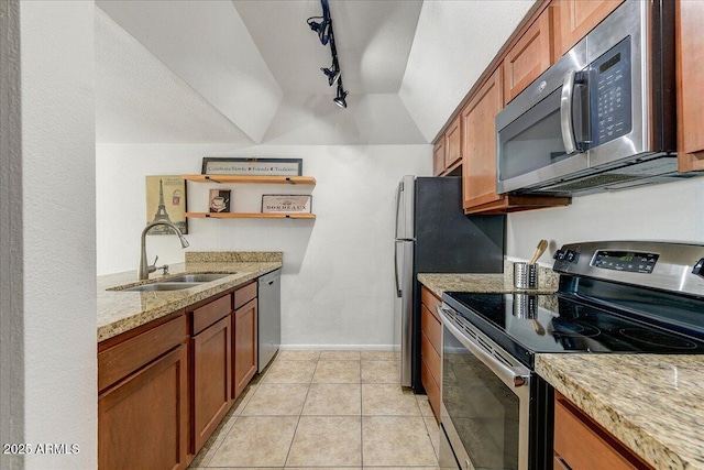 kitchen with lofted ceiling, sink, light tile patterned floors, stainless steel appliances, and light stone countertops