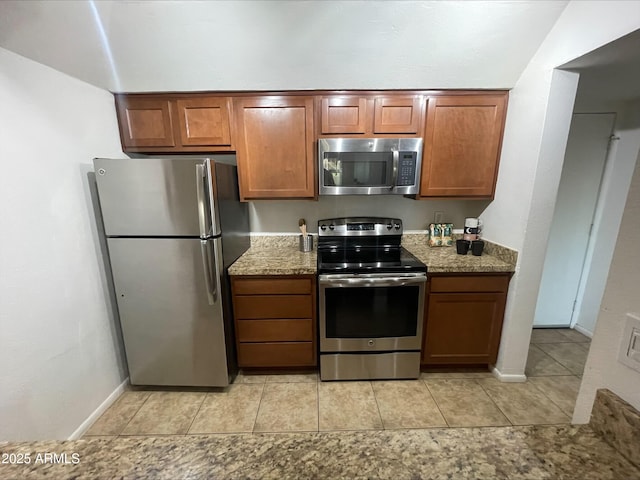 kitchen with stainless steel appliances, stone countertops, and light tile patterned floors