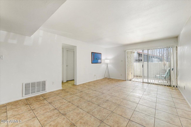 spare room with light tile patterned flooring and a textured ceiling