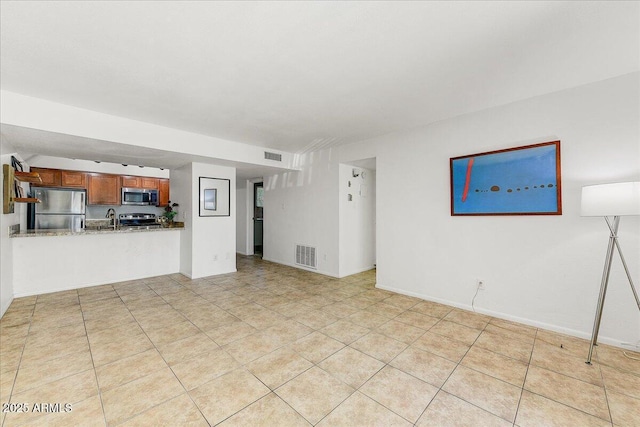 unfurnished living room featuring sink and light tile patterned floors