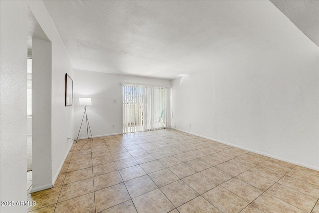 unfurnished room featuring light tile patterned floors and a textured ceiling