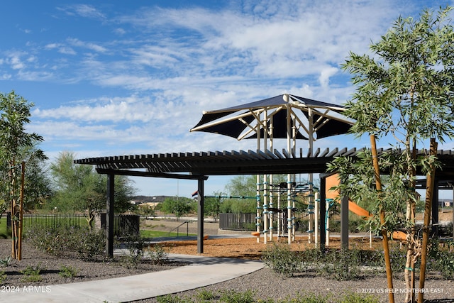 view of property's community with a playground, fence, and a pergola