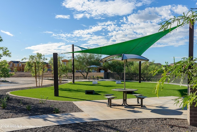 view of home's community with a lawn and fence