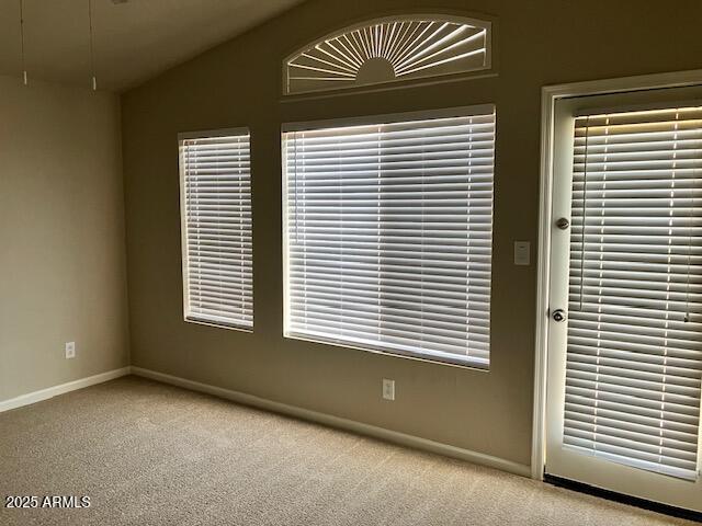 unfurnished room featuring baseboards, light colored carpet, and vaulted ceiling