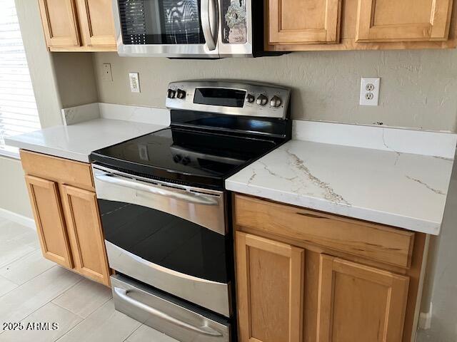 kitchen featuring light stone countertops and stainless steel appliances