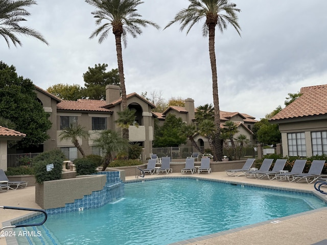 view of swimming pool with pool water feature and a patio