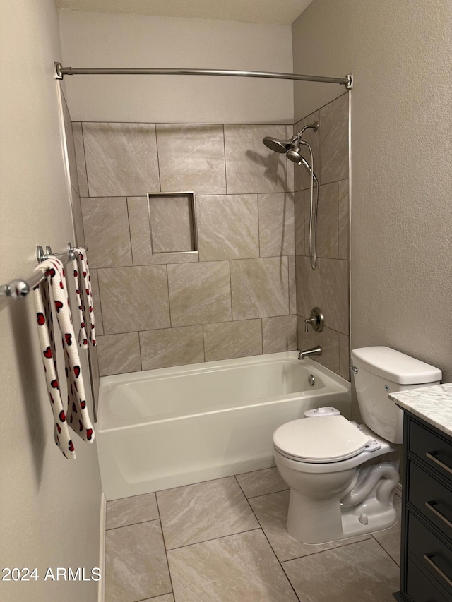 full bathroom featuring toilet, vanity, tiled shower / bath combo, and tile patterned floors