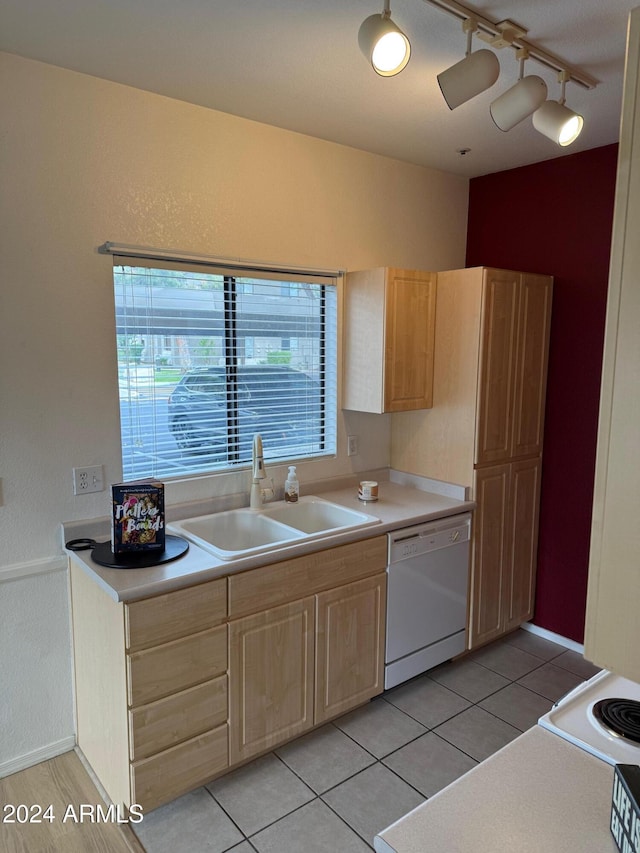 kitchen featuring light brown cabinetry, light tile patterned flooring, white dishwasher, and sink