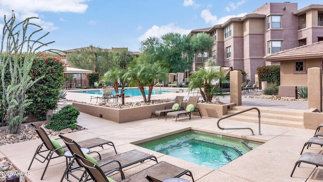 view of pool featuring a hot tub and a patio