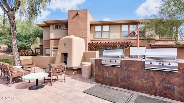 view of patio / terrace with area for grilling and an outdoor fireplace