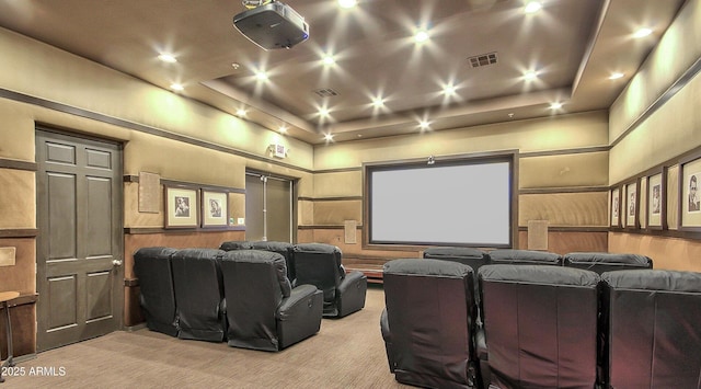 home theater room featuring light carpet, a tray ceiling, and a high ceiling