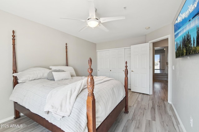 bedroom with light wood finished floors, ceiling fan, baseboards, and a closet