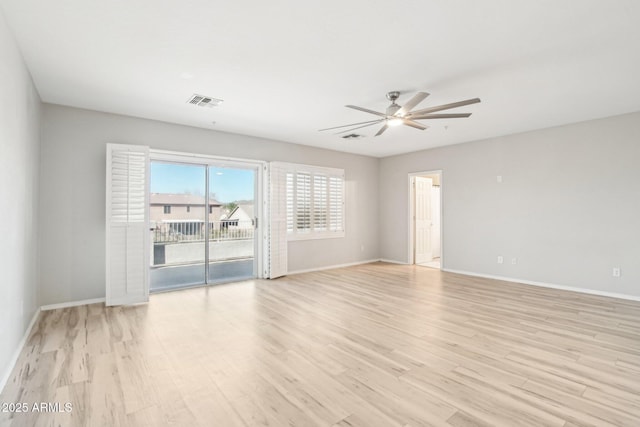 empty room featuring visible vents, light wood-type flooring, a ceiling fan, and baseboards