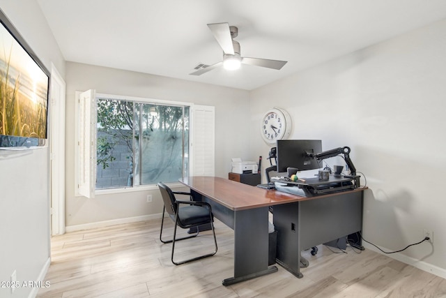 office area with visible vents, light wood finished floors, a ceiling fan, and baseboards