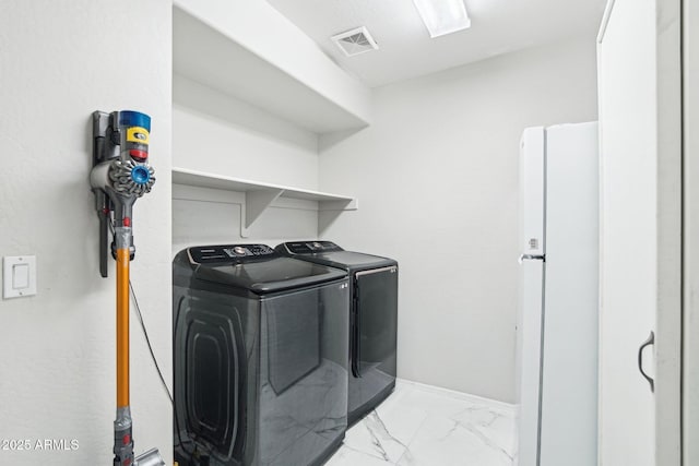 laundry room featuring marble finish floor, visible vents, separate washer and dryer, laundry area, and baseboards