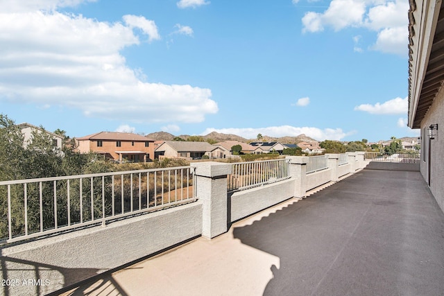 view of patio with a residential view, a mountain view, and a balcony