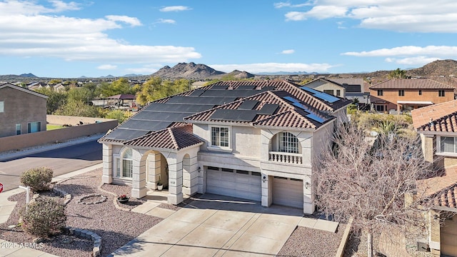 view of front of property with a garage, a mountain view, and solar panels