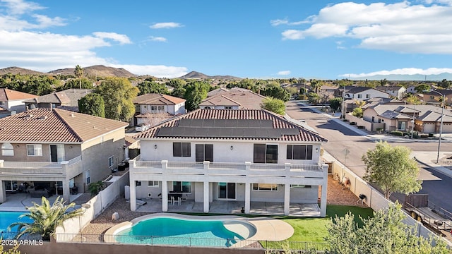 rear view of house with a patio area, a fenced backyard, a residential view, and a mountain view