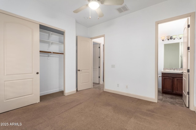 unfurnished bedroom featuring ceiling fan, ensuite bath, carpet, and a closet