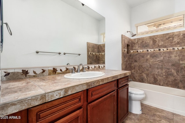 full bathroom featuring toilet, vanity, tile patterned flooring, and tiled shower / bath combo