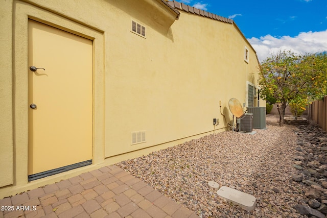 view of property exterior with central AC unit and a patio area