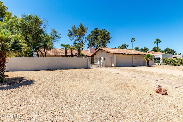 1108 N Oro Vis, Litchfield Park, AZ 85340 - view of front of home featuring a tiled roof, stucco siding, a gate, driveway, and an attached garage