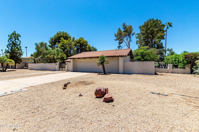 1108 N Oro Vis, Litchfield Park, AZ 85340 - mediterranean / spanish house featuring a tile roof, a fenced front yard, concrete driveway, a gate, and stucco siding
