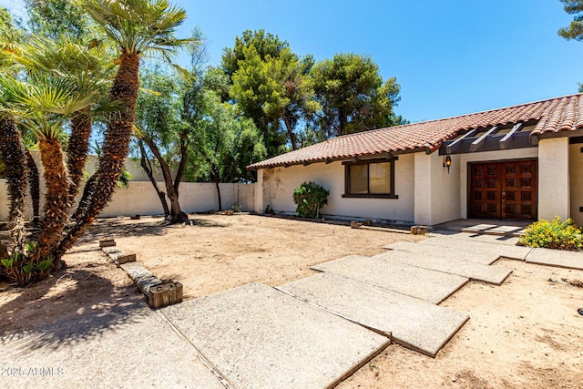 1108 N Oro Vis, Litchfield Park, AZ 85340 - view of side of home featuring a tiled roof, a fenced backyard, stucco siding, and an attached garage