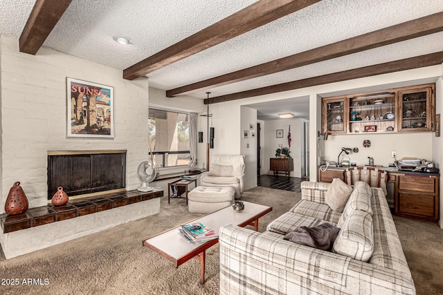 1108 N Oro Vis, Litchfield Park, AZ 85340 - living room featuring carpet flooring, beamed ceiling, a textured ceiling, and a tiled fireplace