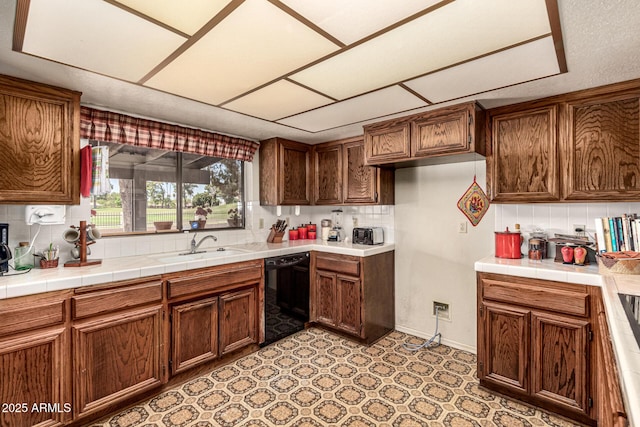 1108 N Oro Vis, Litchfield Park, AZ 85340 - kitchen featuring black dishwasher, tasteful backsplash, and brown cabinetry