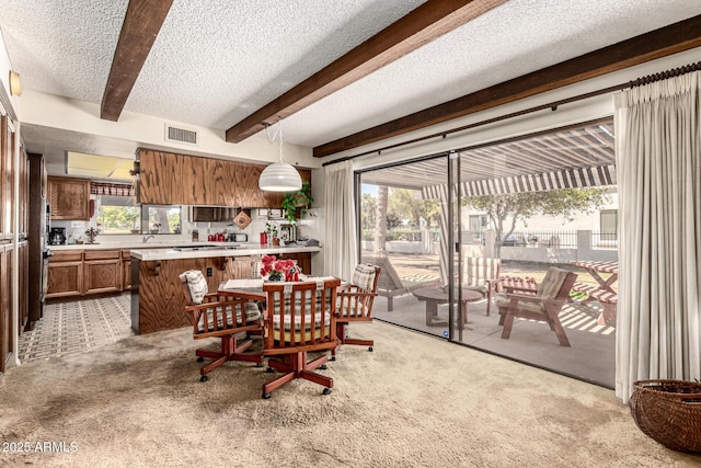 1108 N Oro Vis, Litchfield Park, AZ 85340 - dining space with light carpet, beamed ceiling, and a textured ceiling