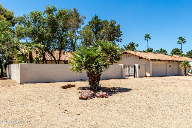 1108 N Oro Vis, Litchfield Park, AZ 85340 - view of front of property with a tile roof, stucco siding, an attached garage, and a gate