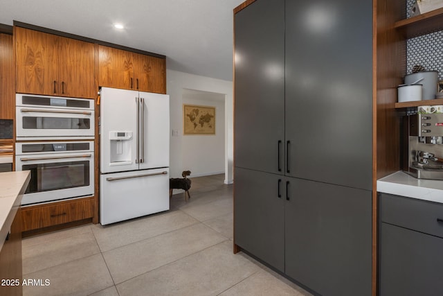 kitchen with light tile patterned flooring, white appliances, and backsplash