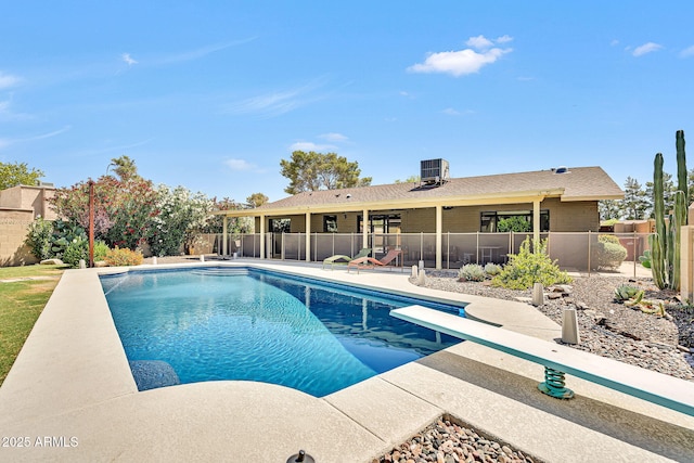 view of swimming pool with a diving board and a patio area