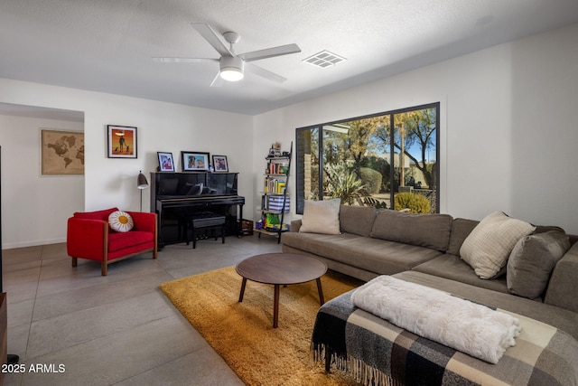 living room featuring ceiling fan and a textured ceiling