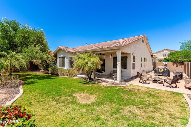 rear view of house with a patio, a ceiling fan, a tile roof, and an outdoor fire pit