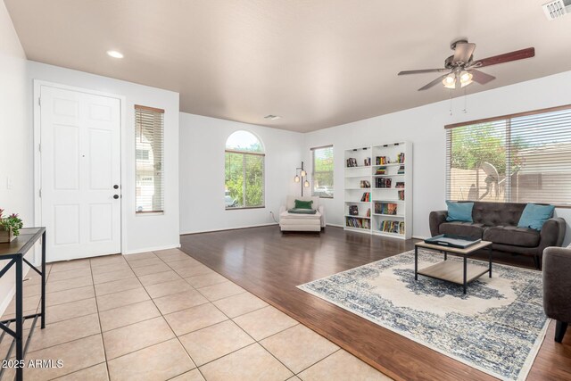 living room featuring plenty of natural light, ceiling fan, wood finished floors, and visible vents