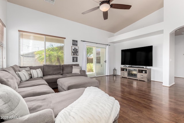 living room featuring arched walkways, high vaulted ceiling, dark wood finished floors, a ceiling fan, and visible vents