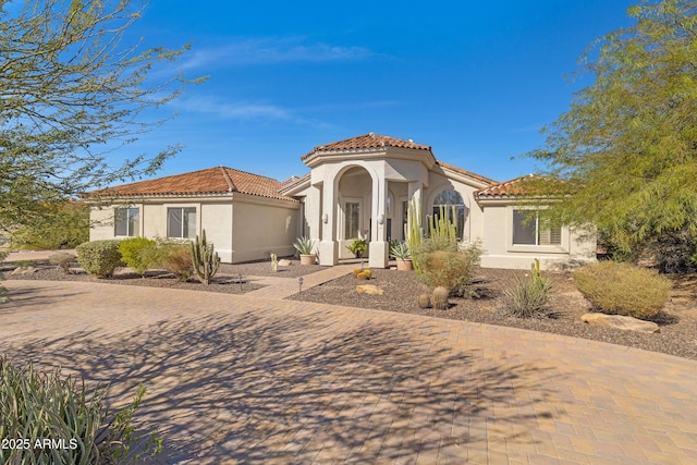 mediterranean / spanish house with stucco siding and a tiled roof