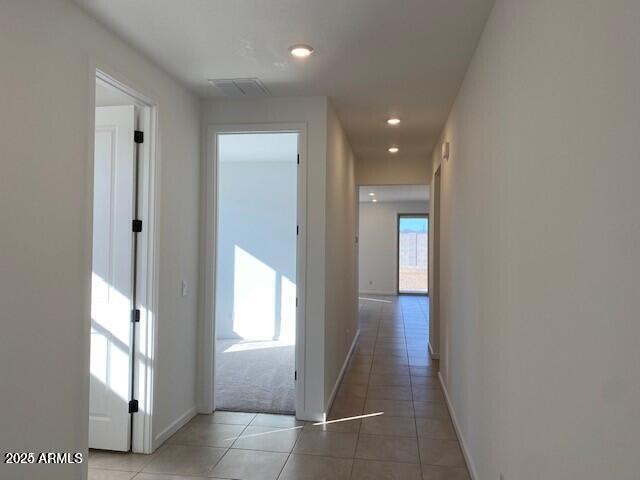 corridor with light tile patterned flooring, visible vents, recessed lighting, and baseboards