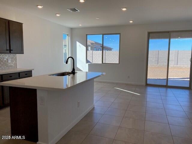 kitchen featuring visible vents, a sink, tasteful backsplash, recessed lighting, and light countertops