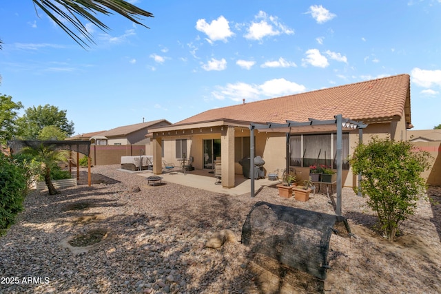 back of property with stucco siding, a patio, a fenced backyard, and an outdoor fire pit