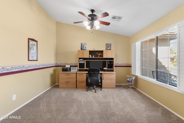 office space with lofted ceiling, baseboards, visible vents, and light carpet