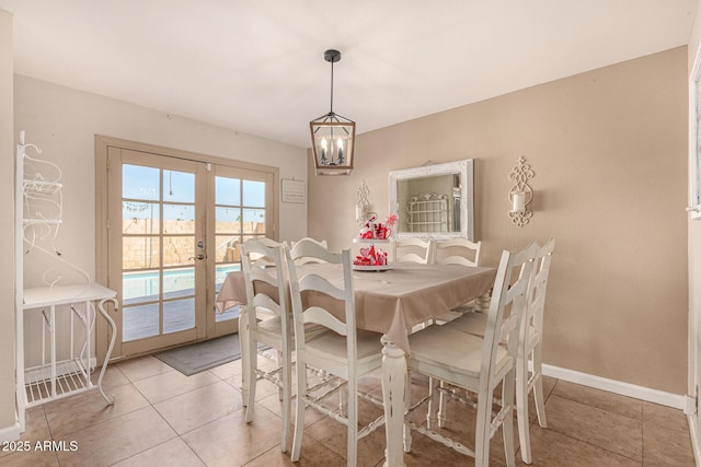 dining room featuring a chandelier, french doors, and light tile patterned flooring