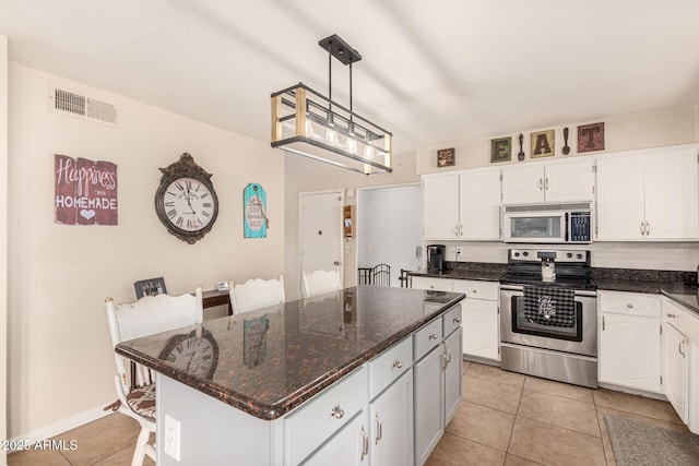 kitchen featuring stainless steel electric stove, a kitchen island, white cabinets, and pendant lighting