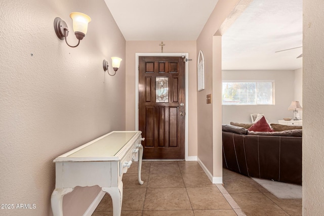 foyer with ceiling fan and light tile patterned floors