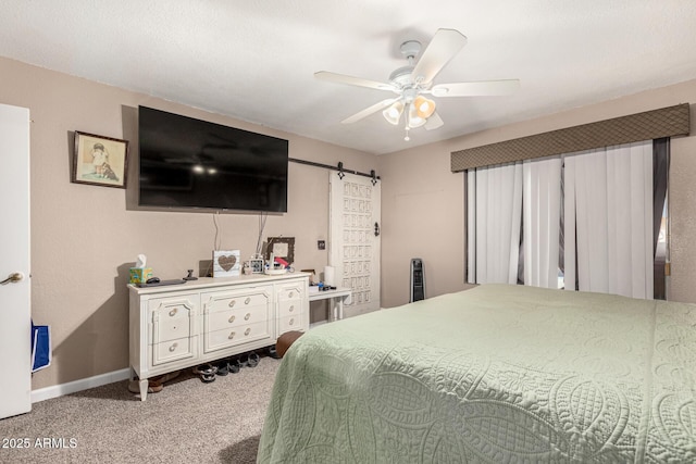 bedroom featuring carpet flooring, ceiling fan, and a barn door