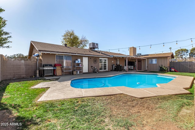 view of pool featuring a grill, a yard, a patio, and central AC unit