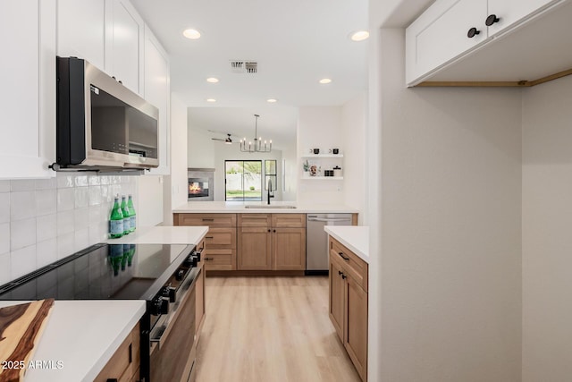 14239 N Edgeworth Dr Unit A, Fountain Hills, AZ 85268 - kitchen featuring stainless steel appliances, light wood-type flooring, decorative backsplash, light countertops, and a chandelier